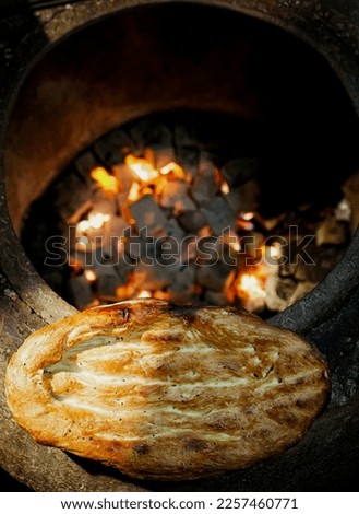 Cooking tandir bread (traditional Azeri bread) in a naan fire oven. Traditional food of Azerbaijan. Royalty-Free Stock Photo #2257460771