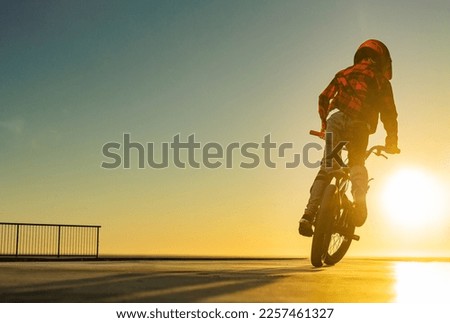 BMX Tricks For Beginners. A teenager bike racing rider in a skate park on a pump track. Download photo for advertising bmx training