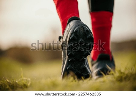 Rear view of a Runner on a Trail and athlete's feet wearing sports shoes for trail running in the mountains. Royalty-Free Stock Photo #2257462335