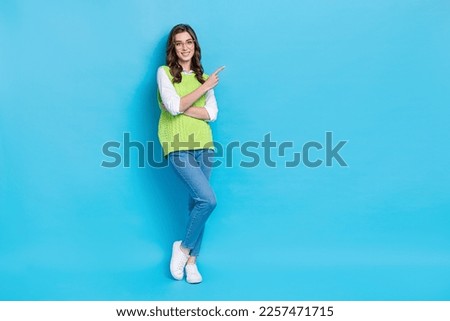 Full body photo of positive nice person indicate finger empty space news isolated on blue color background