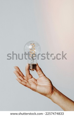 Hand holding a light bulb Royalty-Free Stock Photo #2257474833