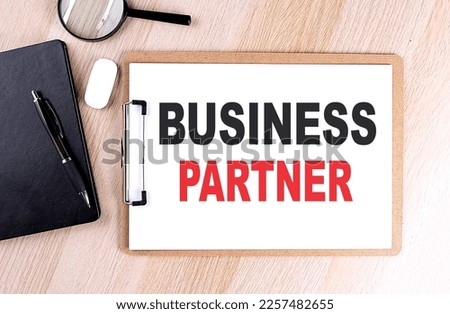 BUSINESS PARTNER text on a clipboard on wooden background
