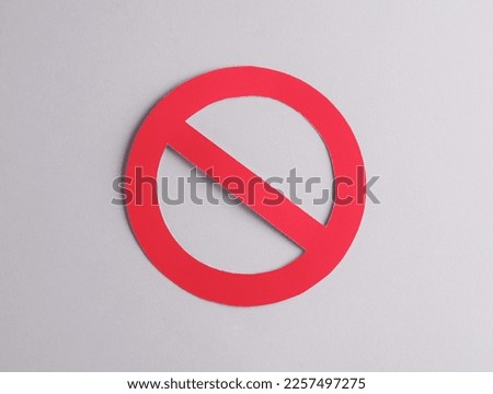 Red prohibition sign cut out of paper on a gray background Royalty-Free Stock Photo #2257497275