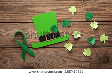St.Patrick 's Day. Paper leprechaun hat with clover leaves and green ribbon on wooden background. March 17. Hand made, Paper art. Flat lay. Top view