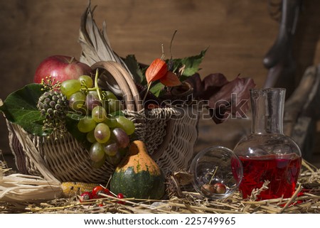 Picturesque autumn composition with basket, fruits, pumpkin, wine on the straw