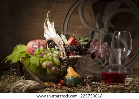 Picturesque autumn composition with basket, fruits, pumpkin, wine on the straw