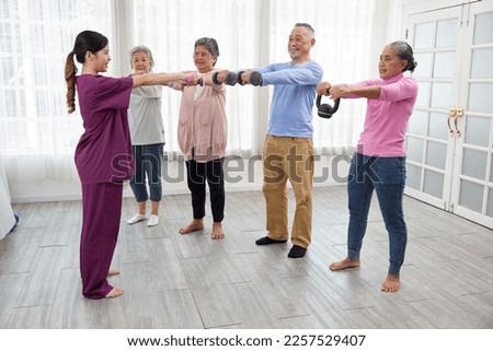 caregiver or nurse using dumbbells exercising and training with senior people in nursing home