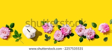 Piggy bank with pink roses overhead view - flat lay