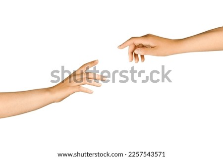 Two isolated hands on a white background try to touch their fingers. Beautiful hands, elegant gesture. Human isolated hands heading towards each other Royalty-Free Stock Photo #2257543571