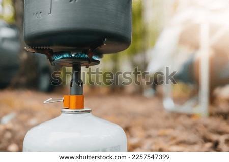 Cooking tourist kettle on portable gas burner. Pan or pot on camping stove. Bushcraft concept. Copy space,