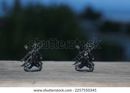 Two chimney sweep figures on a balcony railing.

