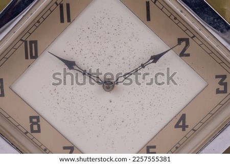 An Art Deco vintage green onyx clock in the shape of an octagon. The time is set at ten past ten. Isolated on a white background.