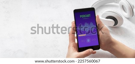 Closeup of woman hands who holding smartphone and listening podcast. White headphones on the white table. Empty space Royalty-Free Stock Photo #2257560067