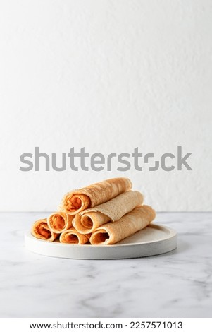 Rolled crepes or thin pancakes on white marble background with copy space. Maslenitsa or Pancake day traditional food concept. Vertical Royalty-Free Stock Photo #2257571013