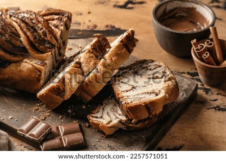 Chocolate Babka or Brioche Bread. Homemade sweet yeast pastry chocolate swirl bread sliced on wooden board. Horisontal orientation Royalty-Free Stock Photo #2257571051