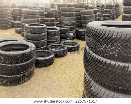 Used tires. Sale of used tires, stacks of different car tires lie on the ground. Buying used tires is a cheap alternative to new. Royalty-Free Stock Photo #2257571517