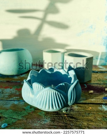 Concrete candlestick in the shape of a lotus of blue color. Shallow depth of field. Mobile photo. Artistic photo.