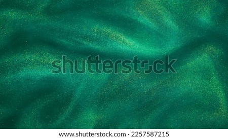 Various stains and overflows of gold particles in green fluid with depth of sharpness. Golden particles dust and smooth defocused background. Liquid iridescent shiny backdrop. Royalty-Free Stock Photo #2257587215