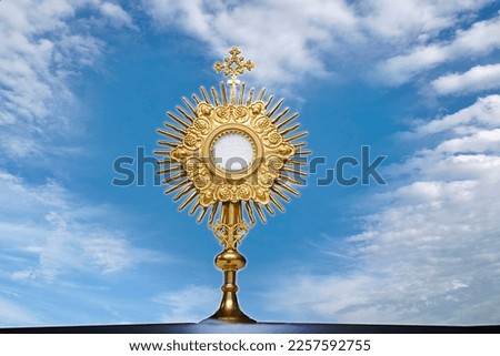Monstrance for adoration in a Catholic church ceremony - Adoration of the Blessed Sacrament - religious symbol on background with blue sky heart shaped Royalty-Free Stock Photo #2257592755