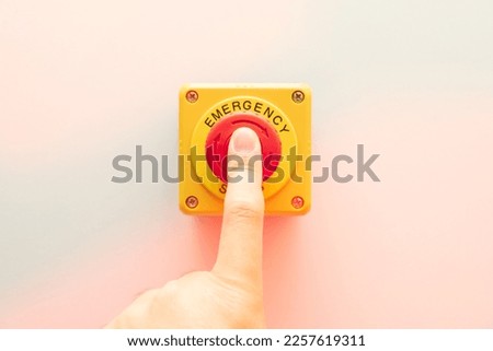 Stop Button and the Hand of Worker About to Press it. emergency stop button. Big Red emergency button or stop button for manual pressing. Royalty-Free Stock Photo #2257619311