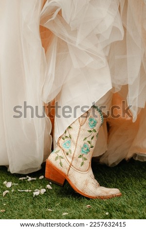 White cowboy boots with floral embroidery with wedding  dress.