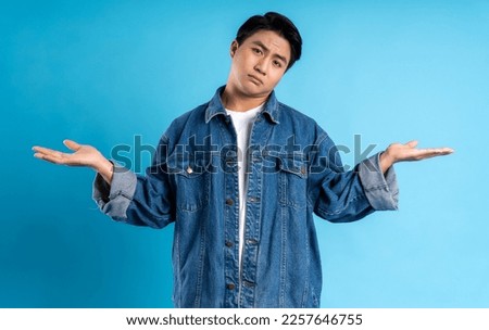 Young asian man posing on a blue background Royalty-Free Stock Photo #2257646755