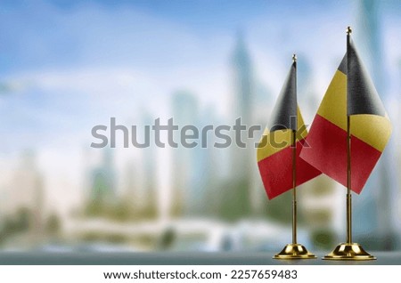 Small flags of the Belgium on an abstract blurry background. Royalty-Free Stock Photo #2257659483