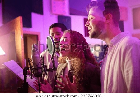 Woman, face or singing group on neon studio microphone in backup singers album, song lyrics or radio recording. Artist, musician or friends in production sound, voice media or light label performance Royalty-Free Stock Photo #2257660301