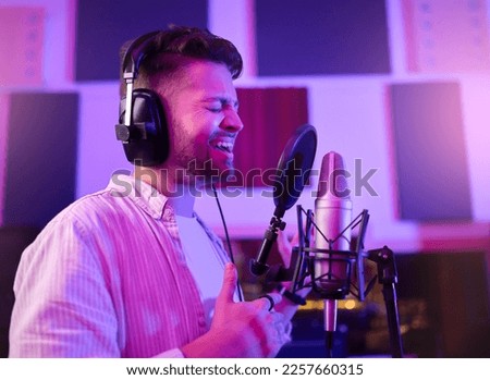 Musician, singer or man on neon microphone, karaoke studio or theatre practice in night booth recording. Singing, person or pop artist on production, voice media or sound performance in light theater