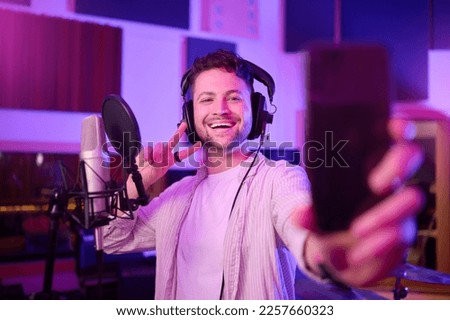 Singer in recording studio, selfie and portrait with peace hand sign, music with mic and headphones. Social media content, happy in picture and audio, podcast or radio dj with man smile with phone
