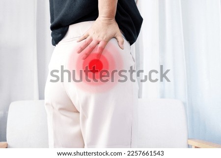 Piriformis syndrome concept with woman suffering from buttock muscle pain when sitting  Royalty-Free Stock Photo #2257661543