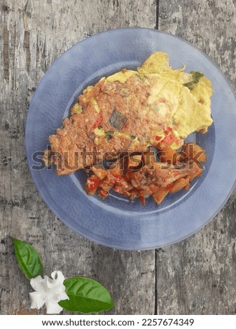 Close up breakfast special, stuffed omelette menu, potatoes and fried chicken on a plate.Homemade.Wooden background.