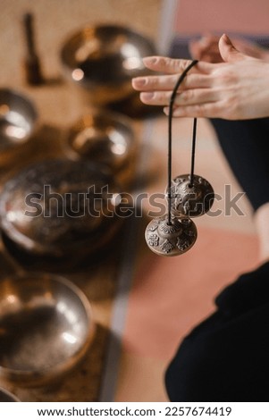 Close-up of a woman's hand holding Tibetan bells for sound therapy. Tibetan cymbals. Royalty-Free Stock Photo #2257674419