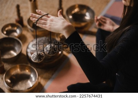 Close-up of a woman's hand holding Tibetan bells for sound therapy. Tibetan cymbals. Royalty-Free Stock Photo #2257674431