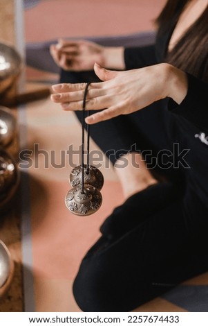 Close-up of a woman's hand holding Tibetan bells for sound therapy. Tibetan cymbals. Royalty-Free Stock Photo #2257674433