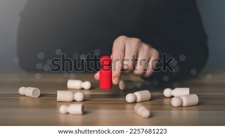 A man hand choosing red wooden figure. The concept of leaders for business success, Leadership, Personnel selection and competition. Job human resources for teamwork. Target customer. manager or CEO. Royalty-Free Stock Photo #2257681223
