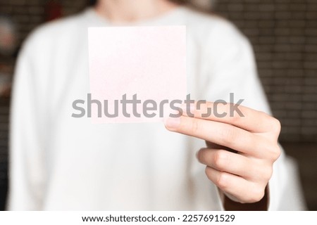 hand is holding a blank brochure booklet. Sheet template, sheet of paper in female hand close-up