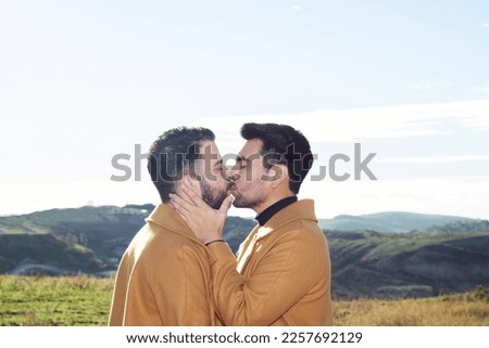 young latin man kissing his boyfriend on hike in nature. gay couple Royalty-Free Stock Photo #2257692129