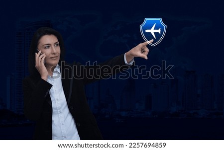Businesswoman talking on her cell phone and pointing finger to airplane with shield icon over world map and city tower, Business travel insurance online, Elements of this image furnished by NASA