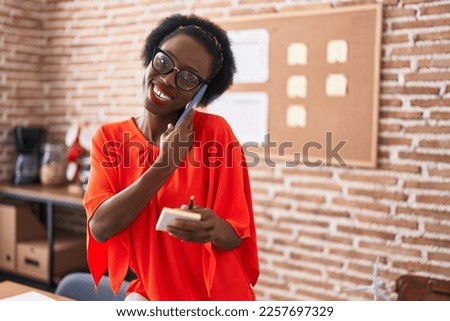 African american woman business worker talking on smartphone working at office