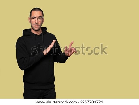 Doubtful young man doing a gesture of keep calm
