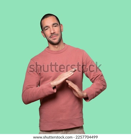Friendly young man making a time out gesture with his hands