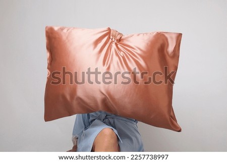 Woman holding a silk pillow case, rose pink silk fabric Royalty-Free Stock Photo #2257738997