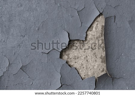Peeling paint on the wall. Old concrete wall with cracked flaking paint. Weathered rough painted surface with patterns of cracks and peeling. High resolution texture for background and design. Closeup Royalty-Free Stock Photo #2257740801