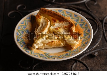 A piece of apple pie on a plate on a dark background. Sliced baked in apple dough. Charlotte.