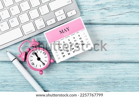 May 2023 Monthly calendar year and alarm clock with keyboard computer on wooden background. Royalty-Free Stock Photo #2257767799