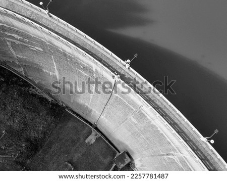 the round shape of a dam seen from above in black and white