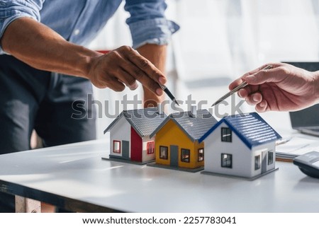 Lawsuits against Real estate agent and realtor general liability insurance businessman professional consultant with house toy model building, choose a house model according to the sample house