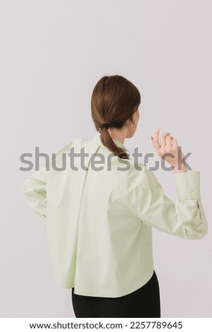 Photo of a beautiful woman in a colorful stylish shirt posing on a white background. Shirt mockup.