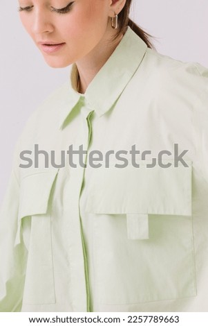 Photo of a beautiful woman in a colorful stylish shirt posing on a white background. Shirt mockup.